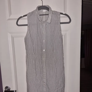 Klänning  - Vit klänning med gråa ränder,  knappar och "snöre" 