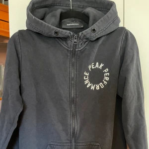 Hoddie  - Mörkblå hoddie från peak med dragkedja i storlek medium. Lite äldre modell och snörena är borta men i gott skick 