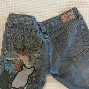 Unika botcut true religions!!☀️❤️ - Trueys som är lågmidjade, De är botcut och har ett coolt tryck där bak💖. Det är en defekt under rumpan som är sydd på maskin med ett annat jeanstyg men syns inte mycket.skriv om ni vill ha mått och är öppen för prisförslag💖💖 