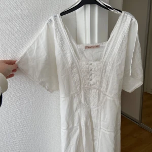 Vit sommarklänning  - Den perfekta sommarklänningen 😍I vitt med band att knyta i ryggen för en fin passform. Storlek M men passar S och liten L också🌸Har nån vaga fläckar på ryggen, men inget som stör mkt, annars så fint skick! Perfekt med boots eller söta sandaler 🌊☀️🌺