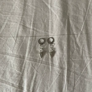 Silverfärgade örhängen med konformade hängen - Ett par trendiga silverfärgade örhängen Örhängena har en enkel och elegant design som passar till olika tillfällen.❤️‍🔥❤️‍🔥