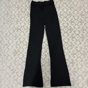 Ribbade utsvängda byxor - Supersköna mörkgråa snygga ribbade utsvängda bootcut byxor med snören, storlek XS men kan passa XXS och S då materialet är lite stretchigt. Riktigt sköna men inte min stil längre 