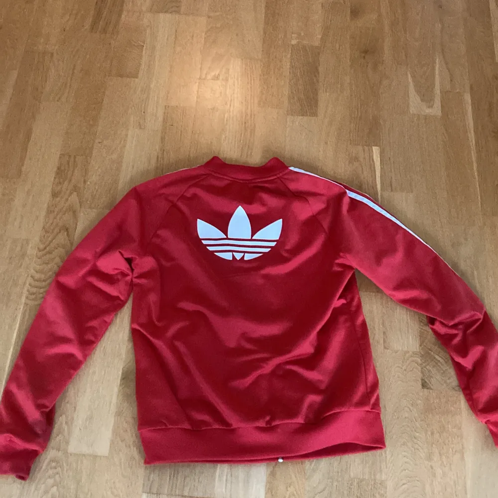 En röd adidas hoodie. Hoodies.