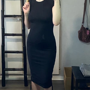 Ribbad t-shirts klänning - Snörerna på sidorna gör att man kan välja vilken längd på klänningen man vill ha, den är ribbad och alldrig använd.