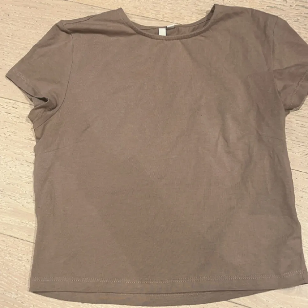 Croppad t-shirt i begie/brun från Nelly. Oanvänd💞💞Hör av dig för fler bilder/frågor.☺️. Toppar.