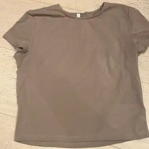 Croppad t-shirt i begie/brun från Nelly. Oanvänd💞💞Hör av dig för fler bilder/frågor.☺️