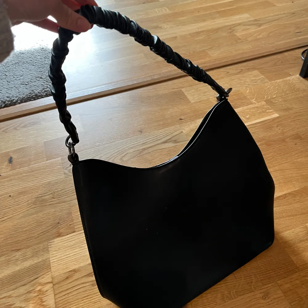En svart väska från zalando, jätte fint skick, med går bandet på bild plus ett lite längre svart. Rymmer vardagliga saker. . Accessoarer.