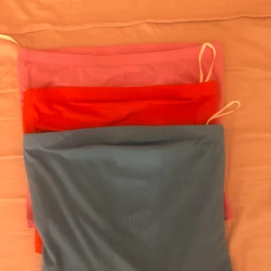 Tubtopp  - Super fina tubtoppar ifrån bikbok. Köptes i sommar för 100 kr stk. Super fina nu till sommaren. Säljer alla tre för 150 totalt eller 70 kr stk( rosa är i storlek m, blå o röd i skr