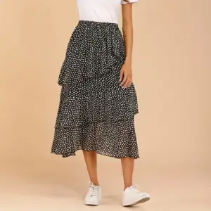 En lång kjol i bra kvalitet och material. Svart och vitprickig design med volanger. 