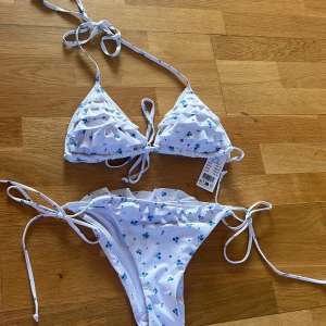 Vit bikini med blå blommor - Verkligen så fin helt oanvänd bikini som tyvärr inte passar mig! Lappen finns fortfarande kvar💗