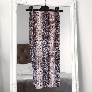 Beige snake kjol XS Gina Tricot  - Färg: beige-mönstrad.  Strl: XS.   Snygg kjol med ormmönster från gina Tricot. Helt NY, aldrig använd. Bred resor i midjan i elastiskt material. Fin lyster.   Kommer ej till användning och stor garderobsrensning pågår!