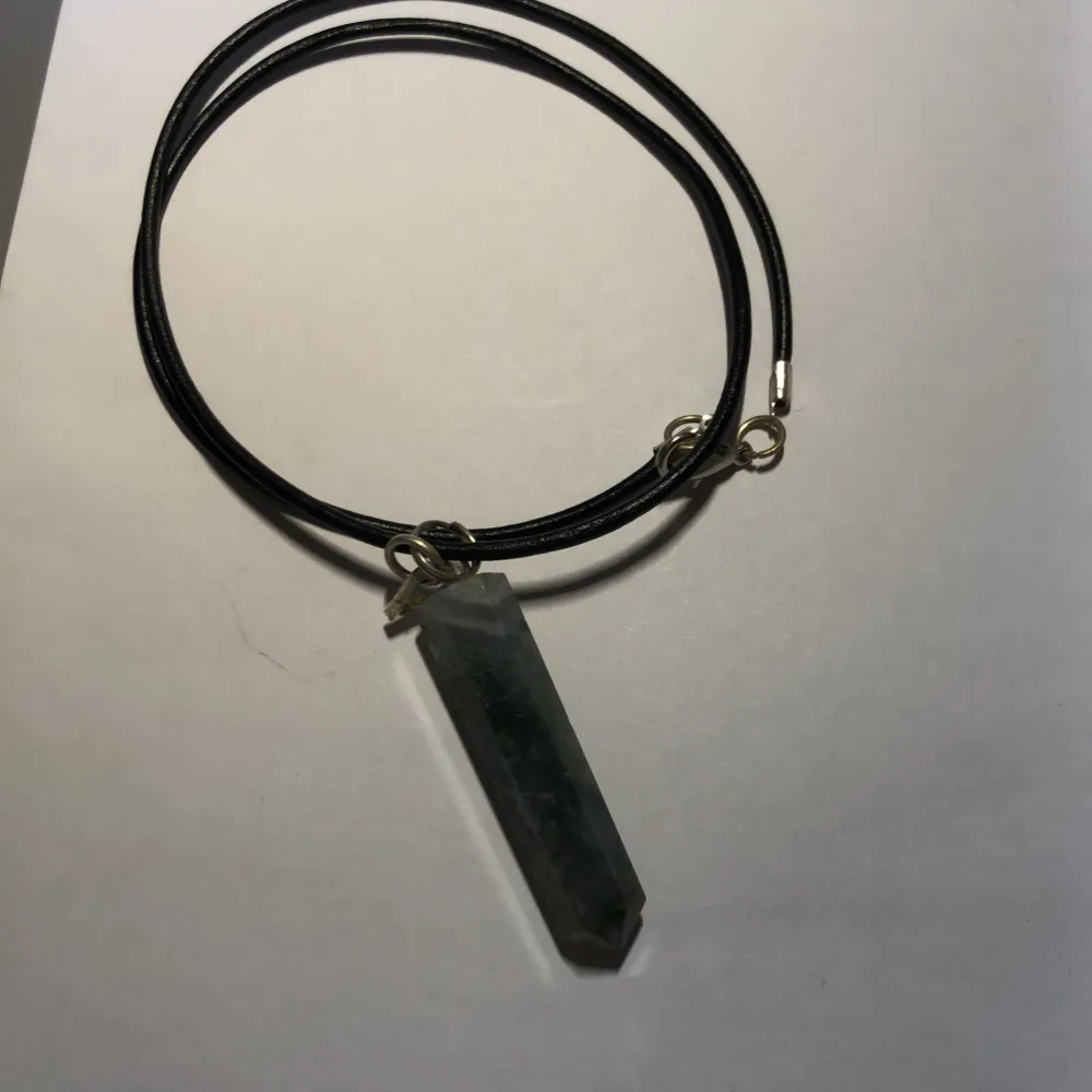 Ett svart halsband med grön kristall. Orginalpris: 160kr. Knappt använt då det inte är min stil.. Accessoarer.