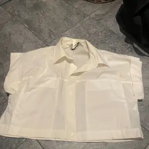 Croppad skjorta som är lite oversized, som inte används. Den är vanilj vit, så en blandning av lite gult o vitt  OBS Köparen står för frakt