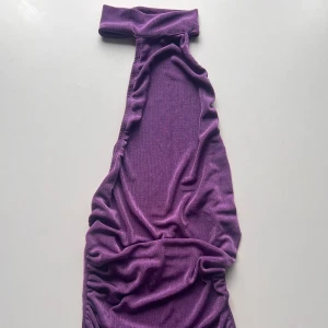 Halterneck topp med öppen rygg  - Topp med halterneck och öppen rygg i glansigt material 