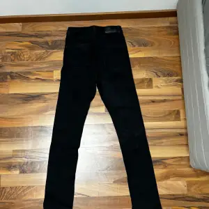 Svarta jeans med slits nedtill från Nelly använda fåtal gånger 