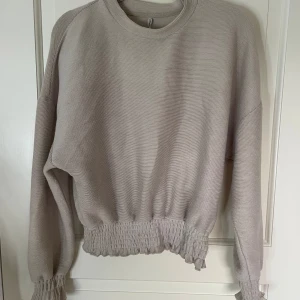 Beige tröja  - Luftig och bekväm tröja! Kramar midjan och runt handleden.