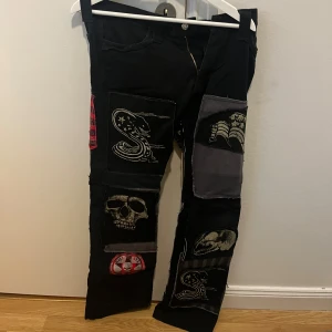 Lågmidjade jeans med tryck - Lågmidjade jeans med många olika typer av tryck. Ganska så långa i passformen. Jag är 167 och de var något långa på mig. (Bild ett framsida, bild två baksida)