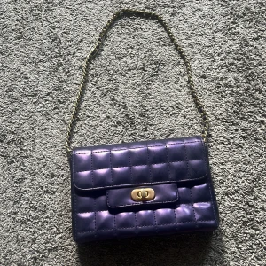 Lila handväska  - En fin lila handväska/ axelväska, den är lite defekt 