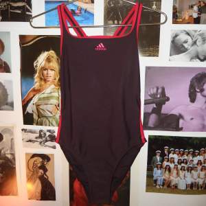 Vintage retro baddräkt från Adidas. Cut out i ryggen. Brunlila med rosa detaljer. Bra skick. Inga lappar men uppskattar som XS/S. 