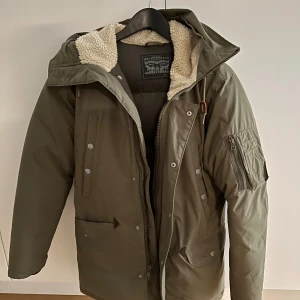 Levi’s Down Puffer Jacket - Storlek: S   Knappt använd, bara legat i garderoben, denna jacka säljs inte längre i butik. Super bekväm och varm jacka, avtagbar päls (inte äkta) med dragkedja du kan byta ut den om du har en äkta päls.  Hör av dig vid fler frågor!
