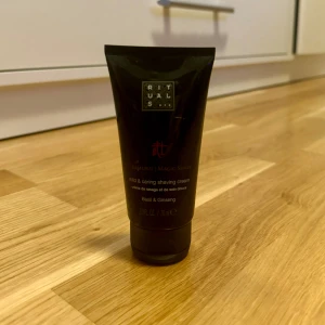 Mild & Caring Shaving Cream från Rituals - En mild och vårdande rakkräm från Rituals med doft av basilika och ginseng. Produkten kommer i en svart tub.