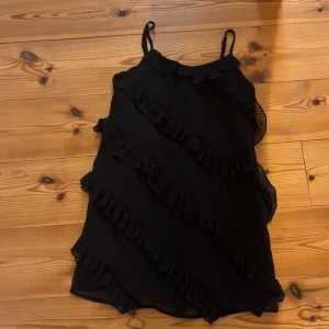 Svart klänning med volanger  - Super bra skick, har bara använt den 2 gånger. Sitter bra och slutar strax över knäna. Jag älskar denna klänning men den har blivit för liten. Skriv om ni är intresserade och vill köpa🥰