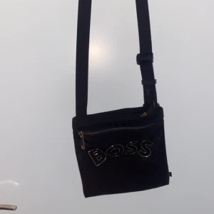 Hugo boss axelväska - Säljer en Hugo boss axelväska då den inte används, inga defekter knappt använd, skriv gärna vid intesse