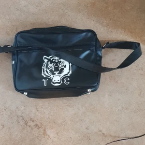Väska - Svart väska. Ted Cole. Med tiger på framsidan. 