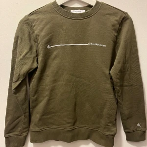 Calvin Klein sweatshirt - Militärgrön/khaki sweatshirt från Calvin Klein i storlek 152/12 år. Säljer pga att den är för liten. Sparsamt använd och i fint skick. Köparen betalar frakt😃