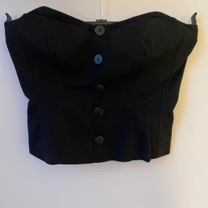 Korsetttopp - Så snygg svart korsettopp med knappar! Passar perfekt till fest eller middag. I jättefint skick! Verkligen så fin säljer bara för att den inte passar mig