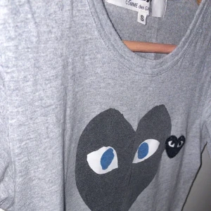  Grå CDG t-shirt - Tja säljer min gamla CDG T-shirt som inte passar i storleken längre, skick 8/10, nypris går för runt 900, vid mer bilder eller frågor så är de bara att skriva!