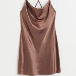 En brun klänning i silkes material, kors i ryggen och öppen. Lägger sig så fint, går ner till låren 🩷 Inga defekter, SOM NY
