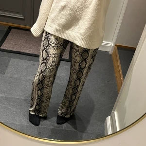 Mönstrade byxor från H&M  - Byxor med ormskinnsmönster från H&M. Jag har sytt om dem från ett par oversize byxor. Storlek 36 och passar mig i längden som är 172. Fint skick. Använd gärna köp nu!