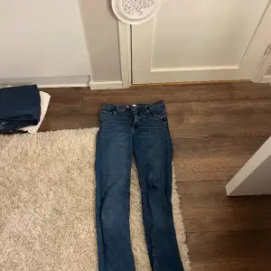 Högmidjade blå jeans med slits. Fint skick, använda en gång. Säljer pga använder inte. 