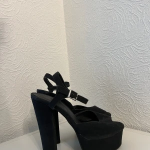 Svarta Nelly klackskor - Fina höga snygga mockaimitation klackskor/pumps från Nelly. Storlek 36. I okej använt skick. Sköna och stabila att gå i. Klackhöjd: 13cm Plattformhöjd: 4cm. Upphämtning i Malmö möjligt. 