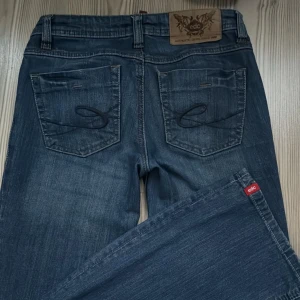 Lågmidjade esprit jeans - Lågmidjade jeans i märket edc by esprit. Det är en väldigt rare modell där temat är kärlek som man kan se inuti byxorna där det är ett litet kärleksbrev skrivet. Byxorna köptes på secondhand och skiftar från ljust till mörkt där bak(bild4) Strl 24/34