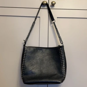 Svart axelväska - Rymlig axelväska med nitar som är köpt second hand. 