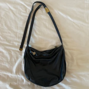 Vintage väska axelremsväska äkta läder - Söt vintage axelremsväska i äkta läder! Köpt på secondhand och aldrig använd av mig. Jag tror att den förra ägaren på något sätt har lagat bandet, kolla bilderna. 