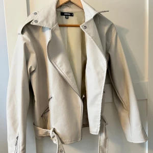 Beige skinnjacka - Beige skinnjacka med skärp. Gott skick, använd fåtal gånger. 