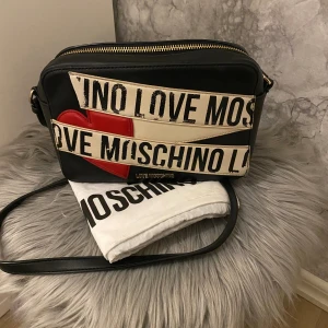 Love moschino väska - Säljer min lite unika love moschino väska som jag köpte ett par år sedan. Den är i bra skick, men kommer inte till så mycket användning längre. 