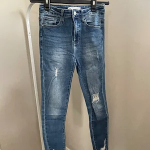 Jeans - Marinblå jeans från i dig denim. Mid waist skinny med lätta hål vid knäna. 