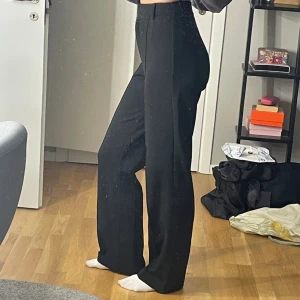 Svarta kostymbyxor  - Svarta högmidjde kostymbyxor i stretchigt material. De är något vida och på bilderna ser ni hur de sitter på mig som 172 cm lång.😊 De kommer från NAKD och är supersköna. 