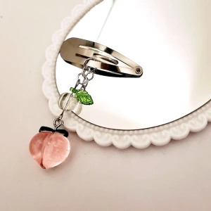 Hårdpänne med en peach - Metallhårspänne med blad och en peach och genomskinlig glaspärla. 