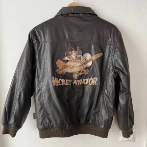 Skinnjacka - Inte äkta skinn! Lite plastigt material men ändå snygg. Trycken är broderade. Liten s eller oversized xs