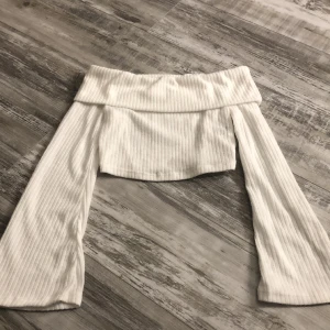 Topp - Säljer den här jätte söta toppen med utsvängda armar och nervikt kant. Den är lite genomskinlig men inte jätte