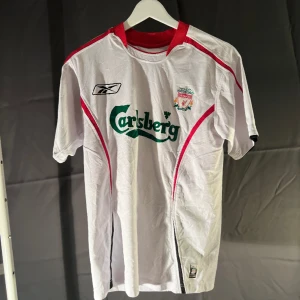 Liverpool tröja - Liverpool tredjetröja från säsongen med nr 23 Carragher på ryggen. Tröjan är från säsongen 05/06 och är i hyfsat bra skick.