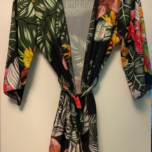 Kimono - Badrock/ Kimono mycket kort, one size men passar mig som är 38-40, kan tänka mig att det är en S/M. Tyg i polyester.