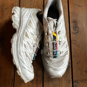 Salomon XT-6 - Ett par vita Salomon XT-6 i stel 40.5, passar mig som har 41 fint.   Smutsiga på bild men ej slitna.  Kan med tvätt se ut så gott som nya, sparsamt använda så inget slitage på sula eller likande. 