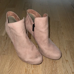 Tamaris stövletter rosa - Stövletter från Tamaris. Sparsamt använda. Lite märke på höger fot (se bild). Ankelhög modell med dragkedja på skaftet. Hög klack ca 9 cm. Innersula: soft, mjuk vilket gör skon bekväm.  Stl 38