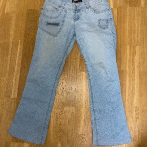 Blå lågmidjade jeans - Blå utsvängda lågmidjade jeans. Köpta på vinted men tyvärr för korta.  Midjemåttet rakt över: 37 cm Men den är stretchig Innerbenslängden: 68 cm Använd gärna köp nu knappen